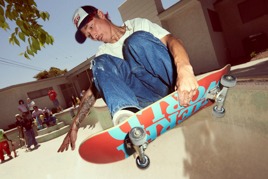 a skateboarder in a empty pool in the air grabbing his board